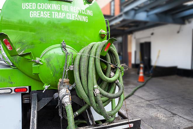 a technician pumping a grease trap in a commercial building in Planada